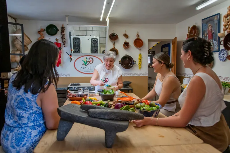 Marilau y sus alumnos cocinando juntos en una clase de cocina mexicana en San Miguel de Allende